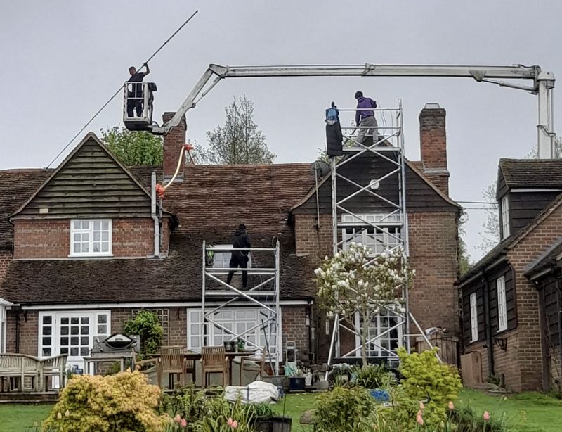 The Roof Moss Cleaners using cherry picker and scaffolding to clean roof safely and professionally in Clapham, Bedfordshire